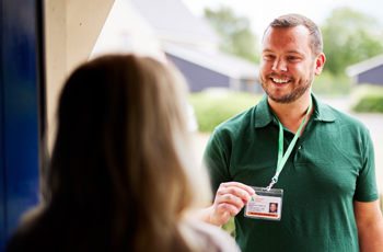 OFTEC technician showing badge to woman at her front door 