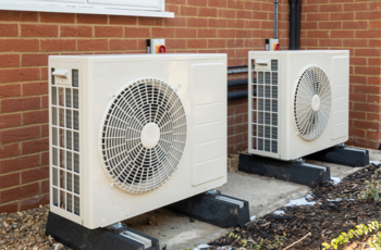 Image of 2 heat pumps outside a residence